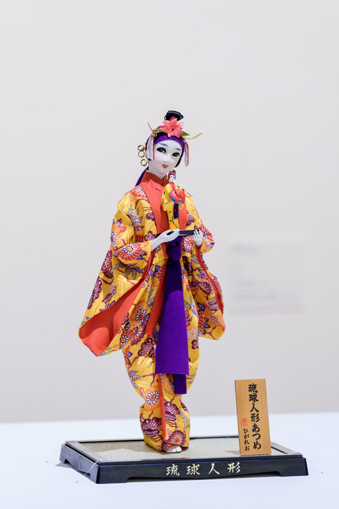 Higaleo Ryukyu Doll Holding Its Own Likeness 2025 Mixed media 26 x 22 x 45 cm Doll Courtesy: Himeyuri Kanko Center Deigo Installation view: Roppongi Crossing 2025: What Passes Is Time. We Are Eternal., Mori Art Museum, Tokyo, 2025-2026 