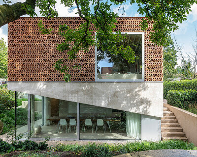 brick lattice facade filters sunlight into renovated 'de zwarte fles' workspace in belgium