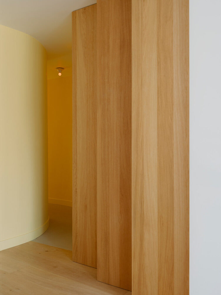 curved walls guide circulation toward a softly lit corridor