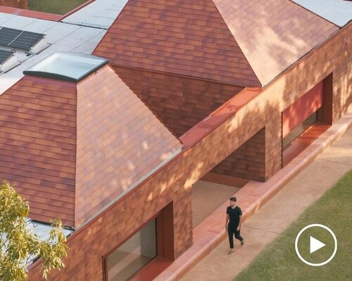 a cluster of terracotta-tiled pyramidal houses envelopes kindergarten in italy