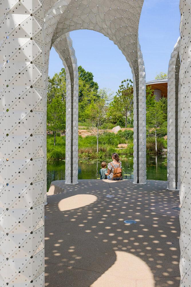 visitors gather beneath the perforated canopy