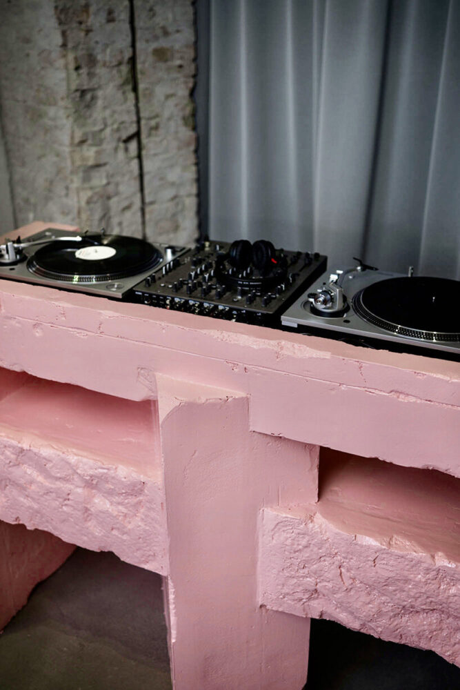 turntables and mixer integrate into the sculptural pink DJ booth 