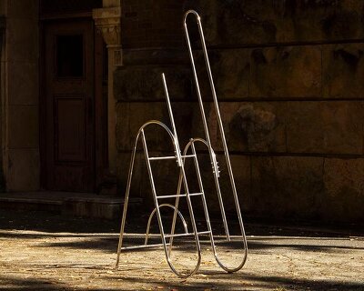 sculptural steel ladder imitates the flowing geometries of brass musical instruments