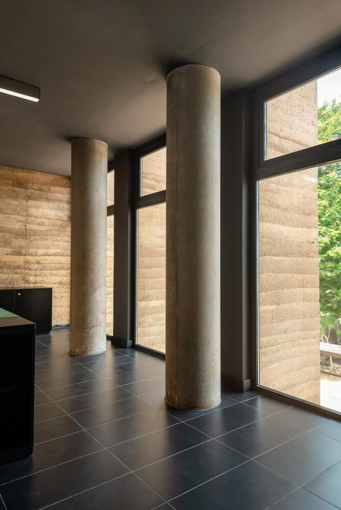 rammed earth walls and columns are expressed both inside and out, creating a consistent, tactile material language