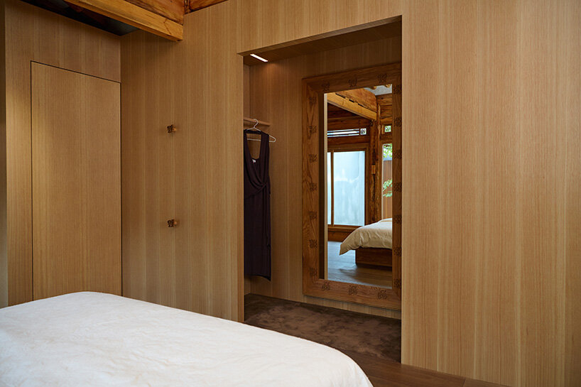 a custom mirror and concealed storage are integrated into the new oak insertions