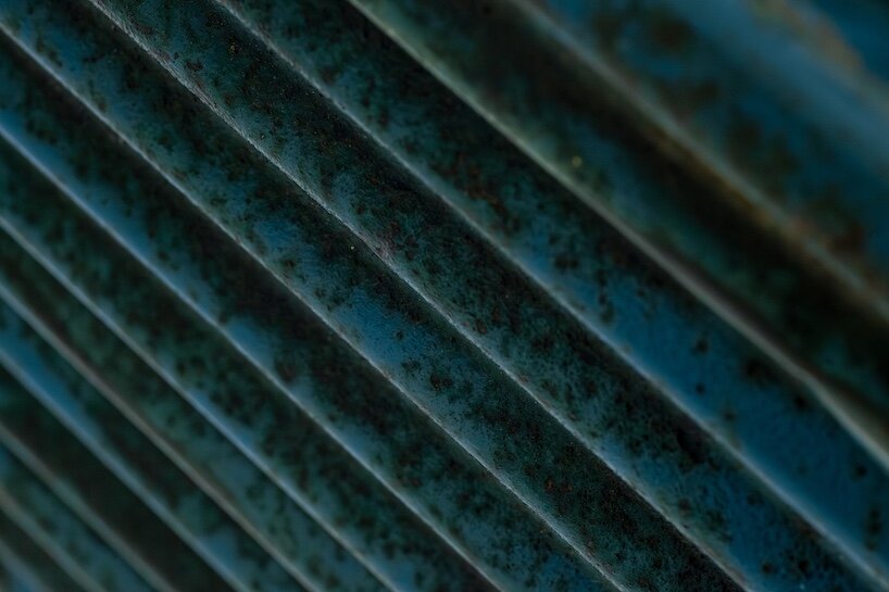 blue-painted corrugated steel’s weathered surface bears the traces of time