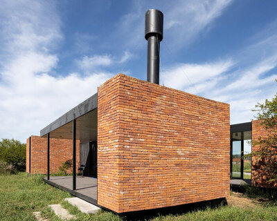 monolithic brick volumes wrap weekend house around a series of courtyards in argentina