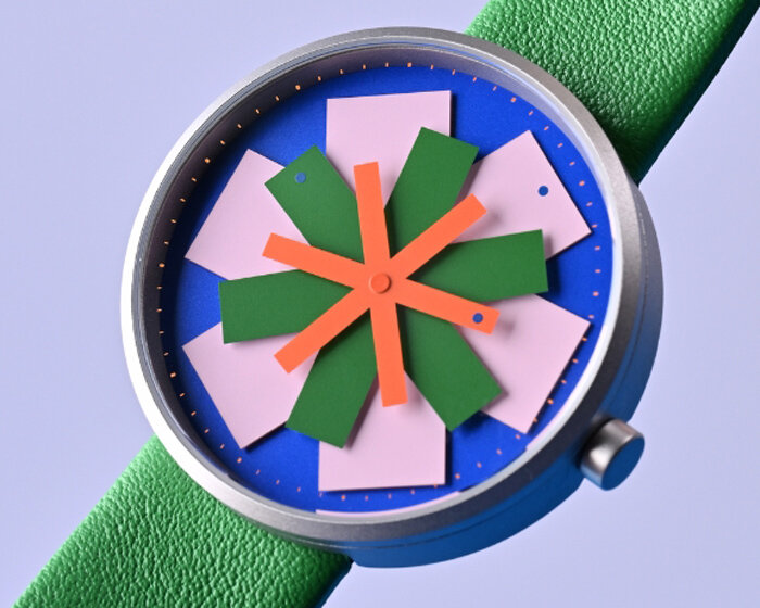 kinetic watch dial reimagines timekeeping through layered colored star-like hands