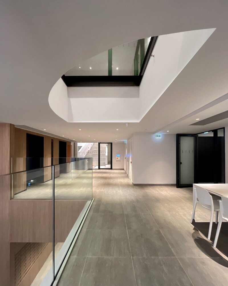 the upper level of the entry lobby connects to the south courtyard, open-air gallery, and visually to the hall and the common room above