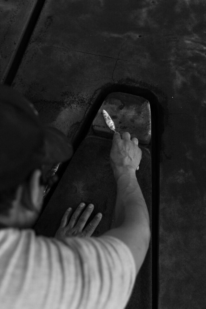 the sand mold is carefully defined by hand, creating the form that will shape the aluminum casting