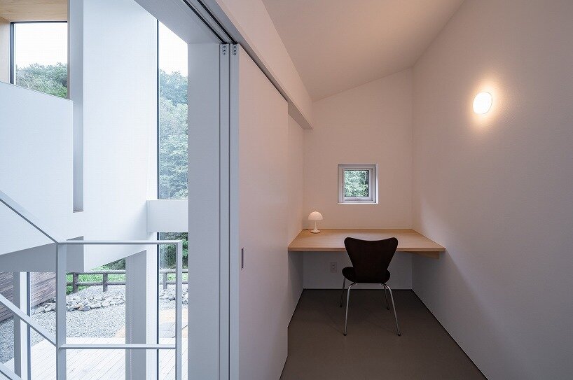 a compact workspace overlooks the forest, bringing nature into everyday routines