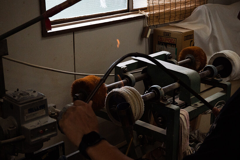 the process of heating bamboo over a fire and bending it | image by Kenta Yoshizawa