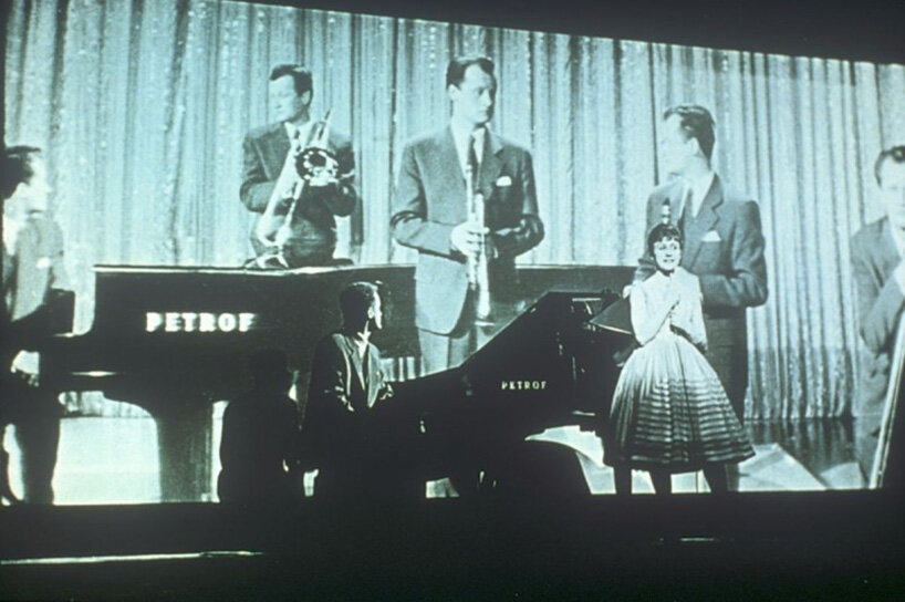 projected musicians appear behind a live pianist and performer