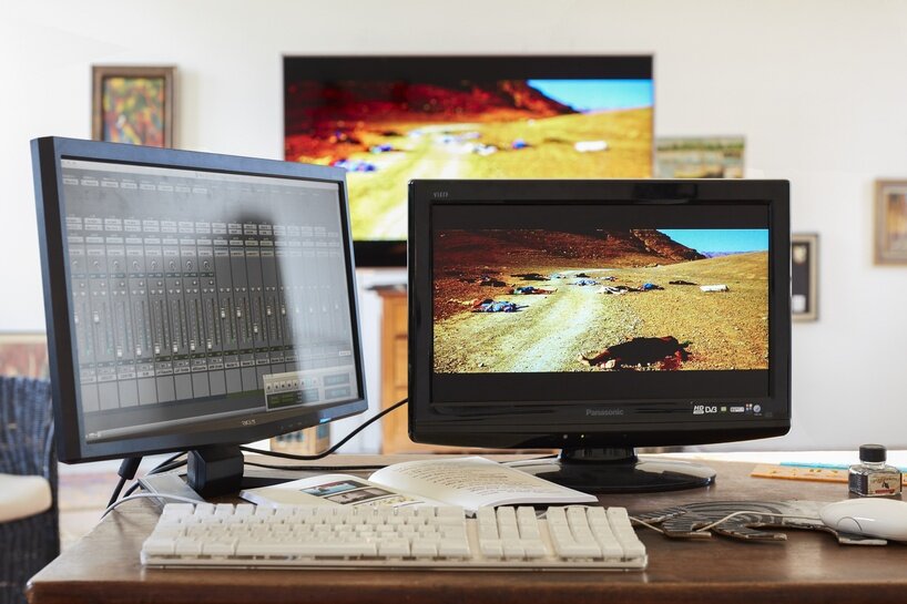 there are two simple wooden tables, pushed up next to each other to create a kind of editing bay