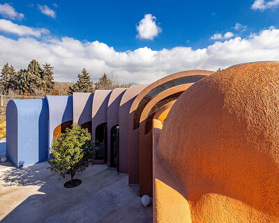 colorful vaulted home by ZAV architects weaves through iranian orchard