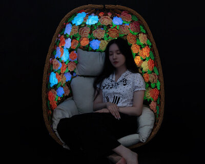 woven bamboo armchair clad in UV-reactive crocheted blooms glows in the dark