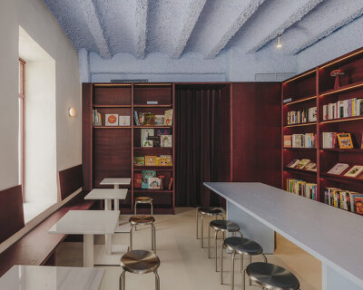 burgundy wood and blue ceilings shape café, bookshop, and wine bar in valencia
