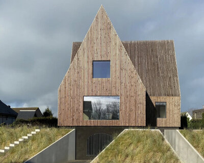 four pitched-roof volumes build timber-clad coastal house in belgium