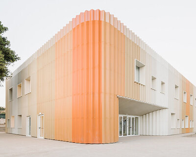 sardinian school wraps in perforated aluminum facade to enclose flexible agorà