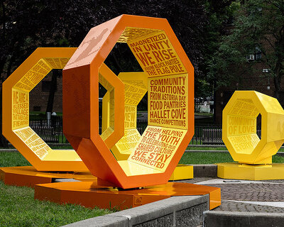 rotating octagonal forms marked with community voices shape queens landmark