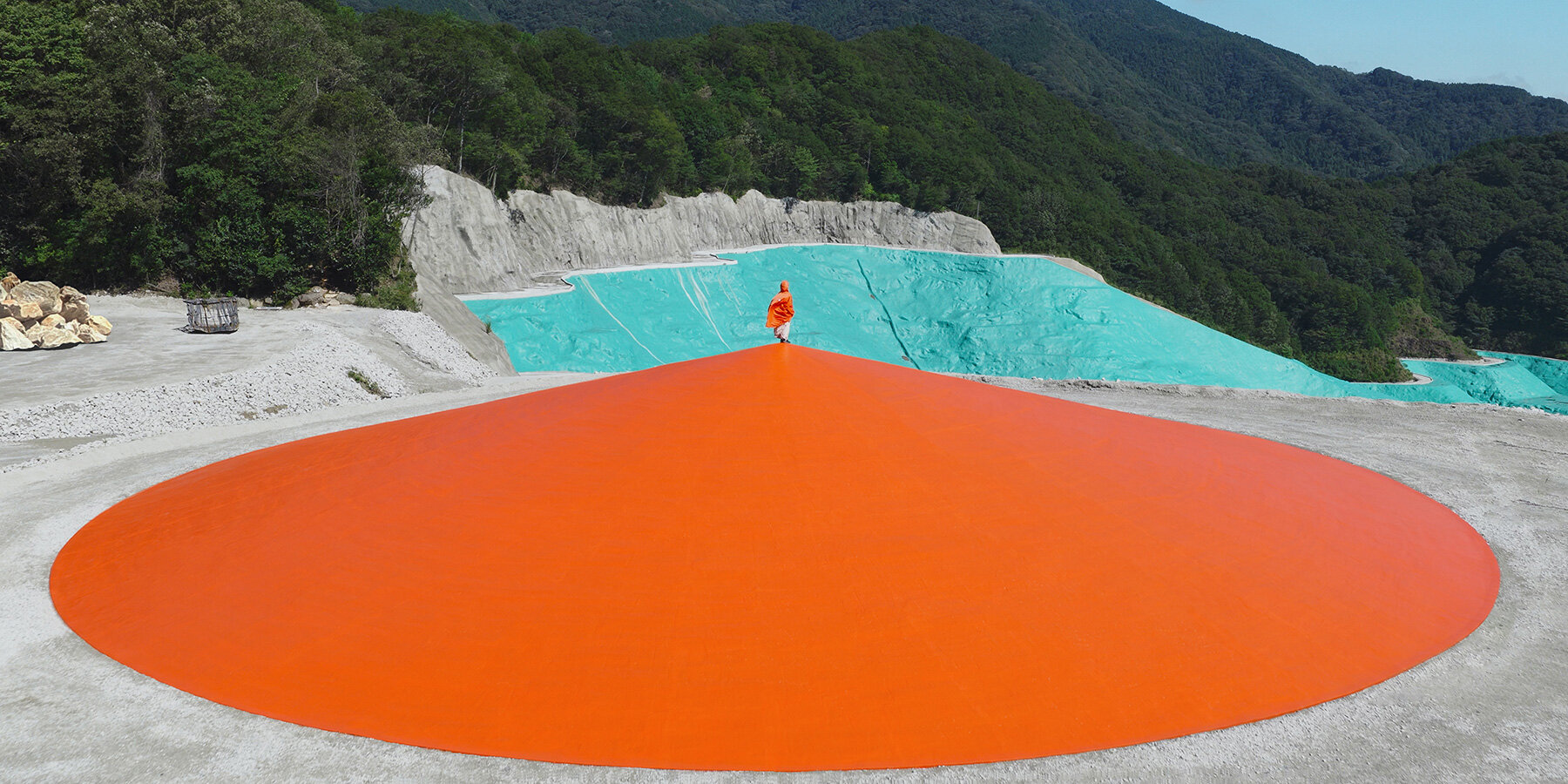 ryue nishizawa places vivid orange peak against turquoise landfill in japan