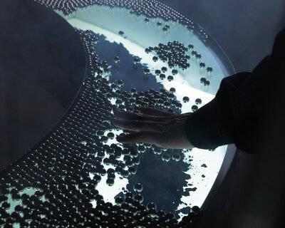 steel spheres moving across curved glass frame leonardo garza’s sensory installation for BYREDO